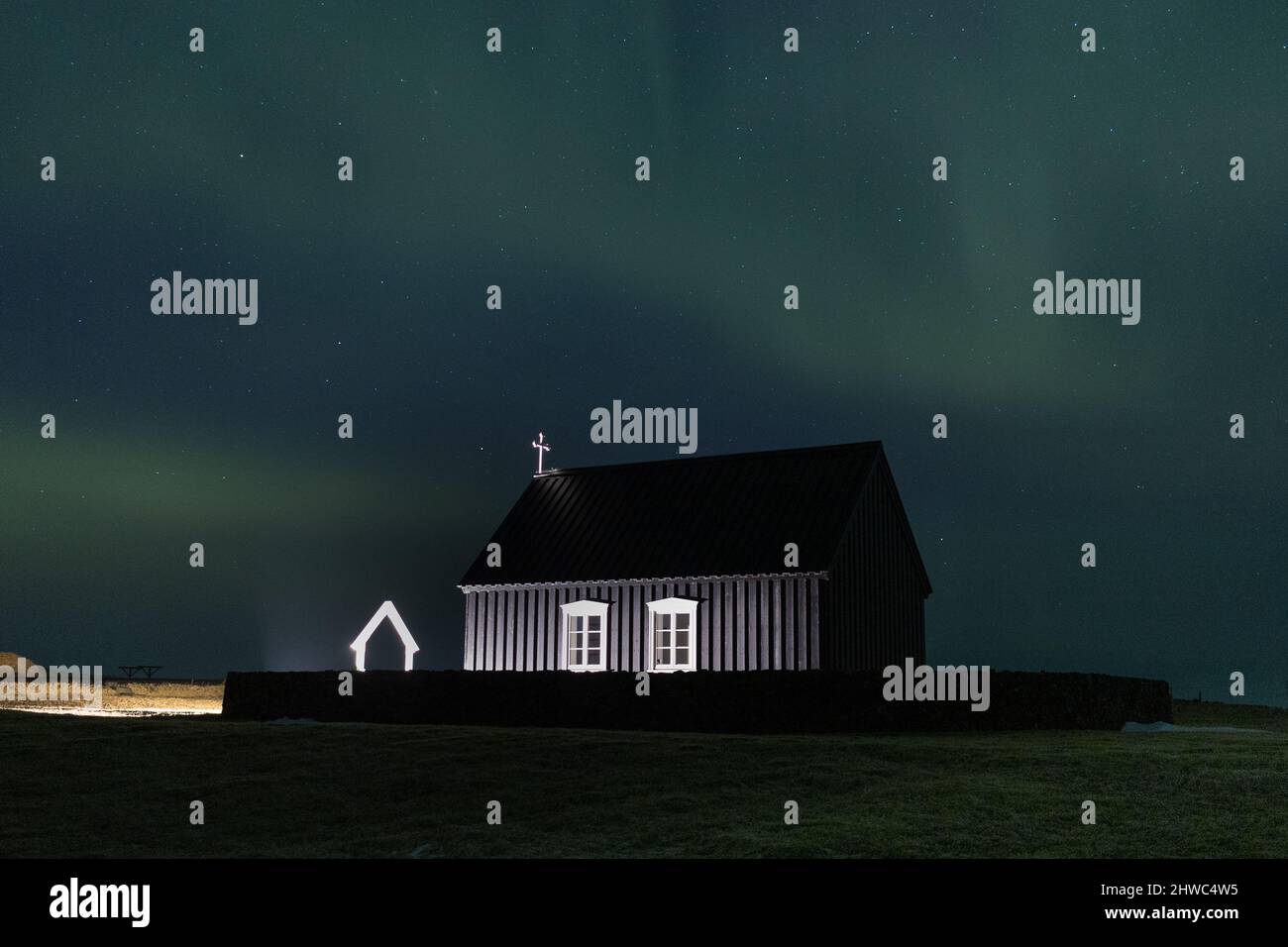 Aurora boreale su una chiesa nera in Islanda Foto Stock