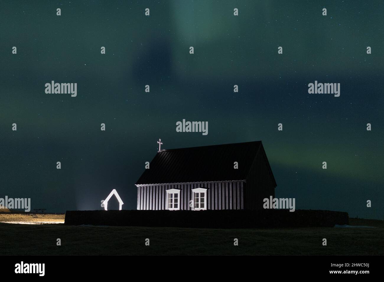Aurora boreale su una chiesa nera in Islanda Foto Stock