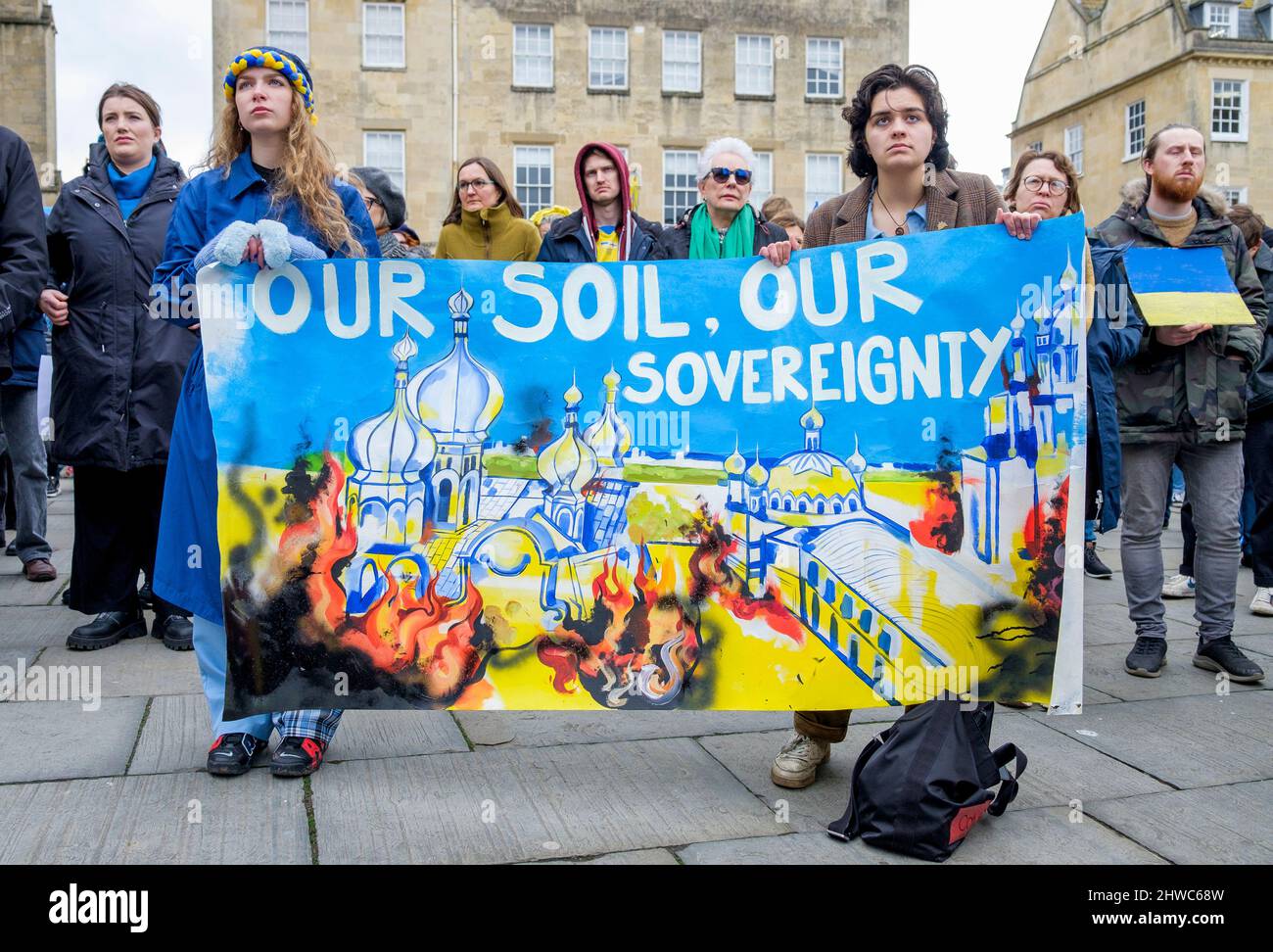 Bath, Regno Unito. 5th marzo 2022. I manifestanti tengono una bandiera a sostegno dell'Ucraina mentre ascoltano i discorsi davanti all'Abbazia di Bath durante una dimostrazione contro l'invasione russa dell'Ucraina. La manifestazione è stata organizzata per consentire alla popolazione locale di dimostrare la propria solidarietà con l'Ucraina nella guerra Russia-Ucraina e condannare le azioni di Putin. Credit: Lynchpics/Alamy Live News Foto Stock