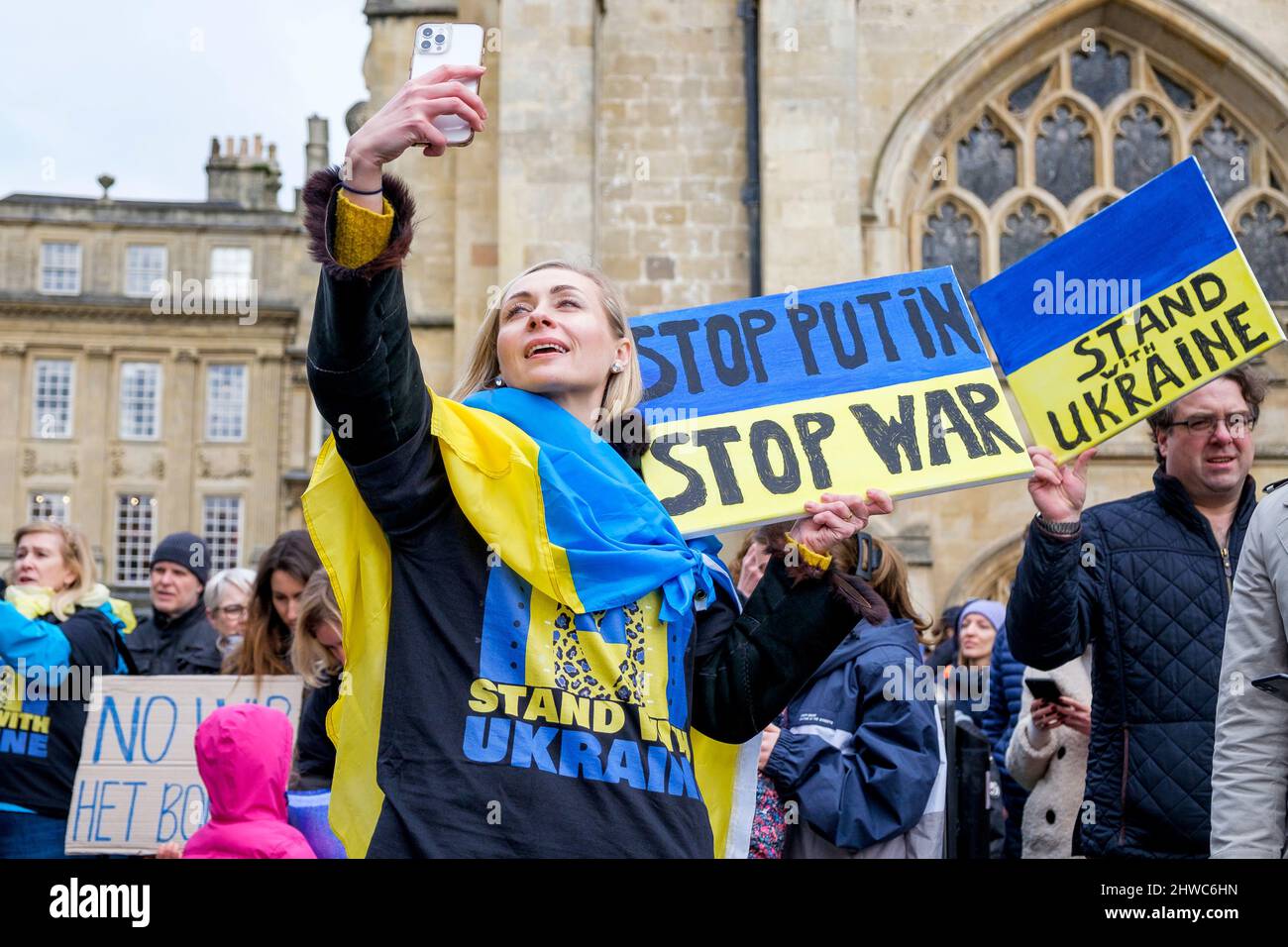 Bath, Regno Unito. 5th marzo 2022. Una donna drapponata alla bandiera Ucraina prende un selfie di fronte all'Abbazia di Bath durante una dimostrazione contro l'invasione russa dell'Ucraina. La manifestazione è stata organizzata per consentire alla popolazione locale di dimostrare la propria solidarietà con l'Ucraina nella guerra Russia-Ucraina e condannare le azioni di Putin. Credit: Lynchpics/Alamy Live News Foto Stock