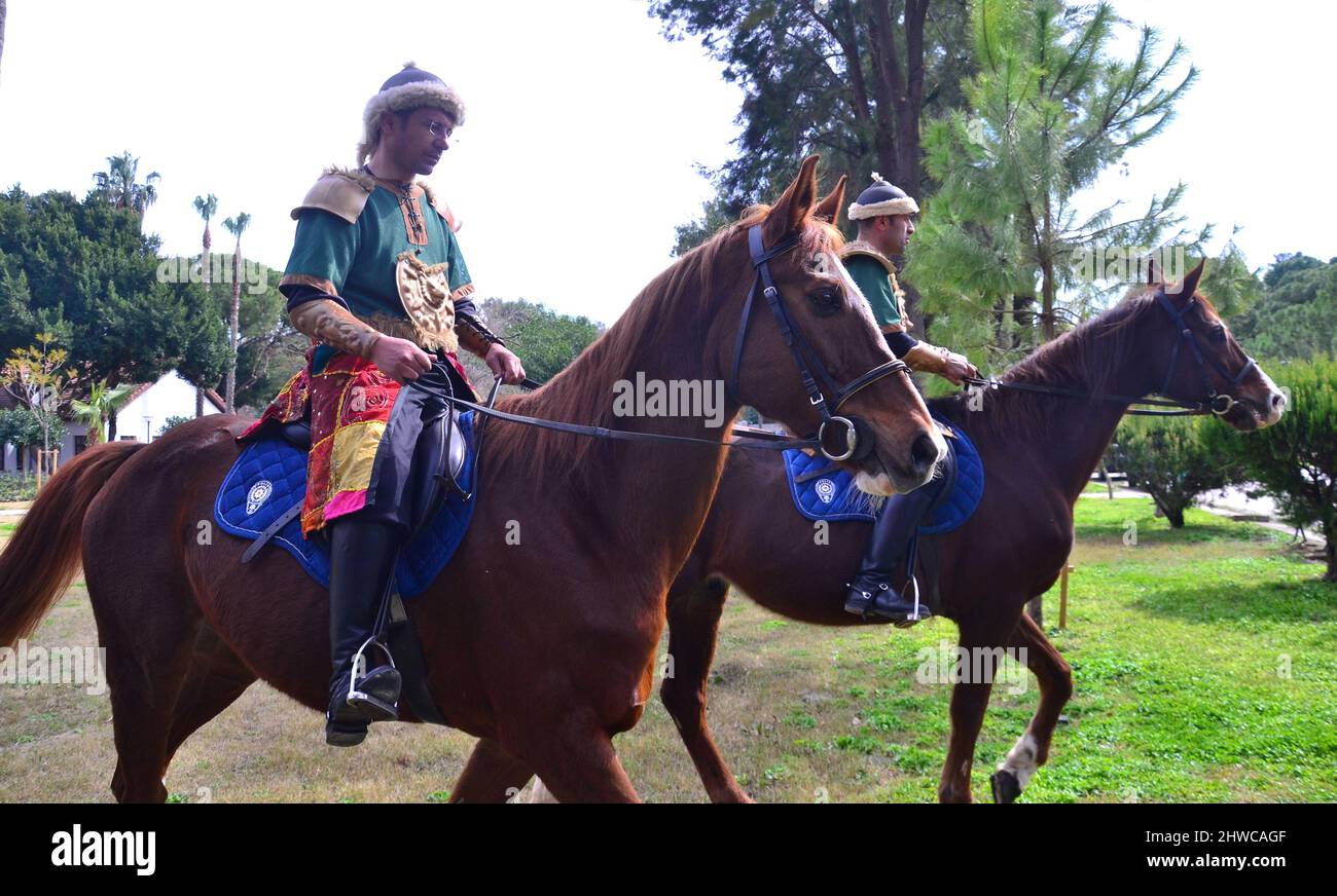 Gli uomini che indossano costumi tradizionali turchi cavalcano i cavalli durante un evento per celebrare il 815th anniversario della conquista di Antalya, Turchia, da parte di Gıyaseddin Keyhüsrev nel Parco di Karaalioğlu, Antalya, Turchia, il 5th marzo 2022. L'evento è visto come una celebrazione della libertà. Foto Stock