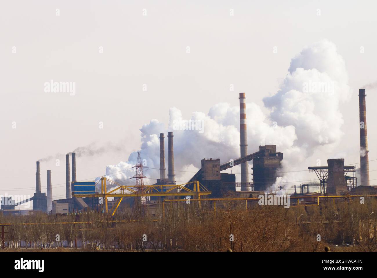 Inquinare l'aria una nuvola alla volta. Colpo di inquinamento atmosferico su un'area industriale. Foto Stock