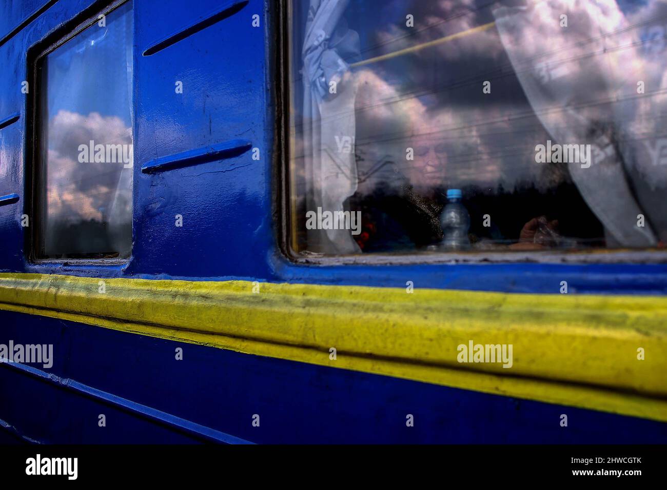 Una donna vista attraverso una finestra di treno a Olkusz stazione ferroviaria oltre 700.000 ucraini cercano rifugio in Polonia a causa dell'aggressione di Russiaís sul loro paese. Molti di loro vengono in città polacche in treno, dove viene organizzato un aiuto umanitario per coloro che ne hanno bisogno. Foto Stock