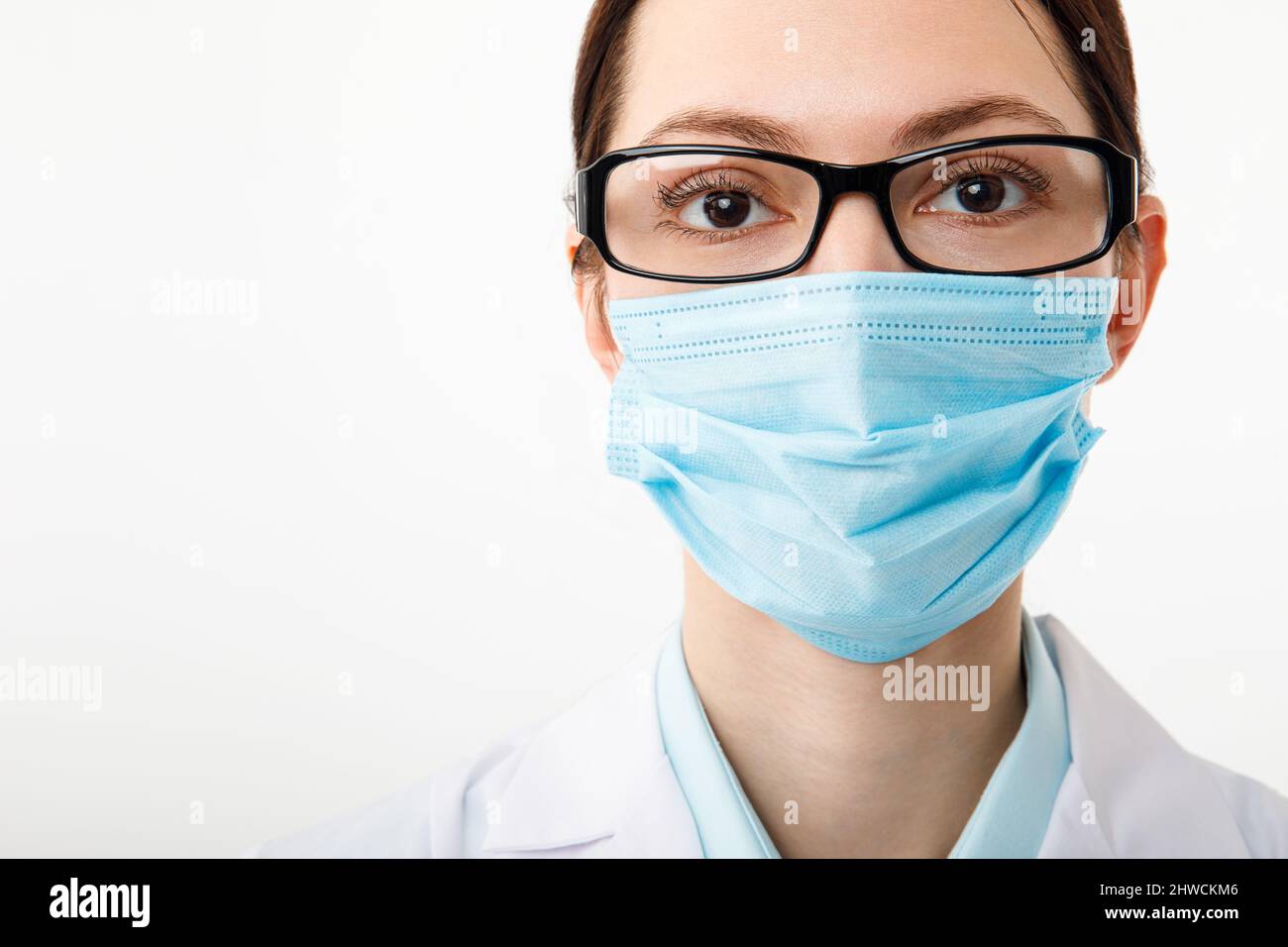 Ritratto di un medico in una maschera medica su sfondo bianco Foto Stock