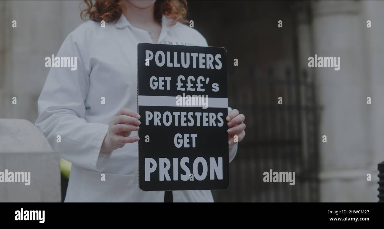 Londra, UK - 11 20 2021: PRIMO PIANO di uno scienziato che ha firmato “chi inquina riceve ££, i manifestanti ricevono carcere” a sostegno di un detenuto insulato in Gran Bretagna. Foto Stock
