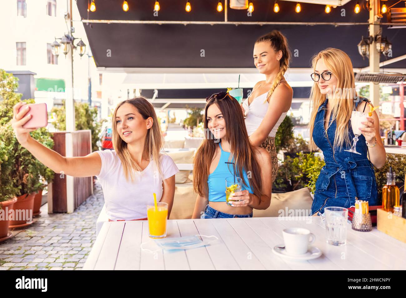 Happy hipster ragazze che prendono selfie al ristorante pub bere cocktail Foto Stock
