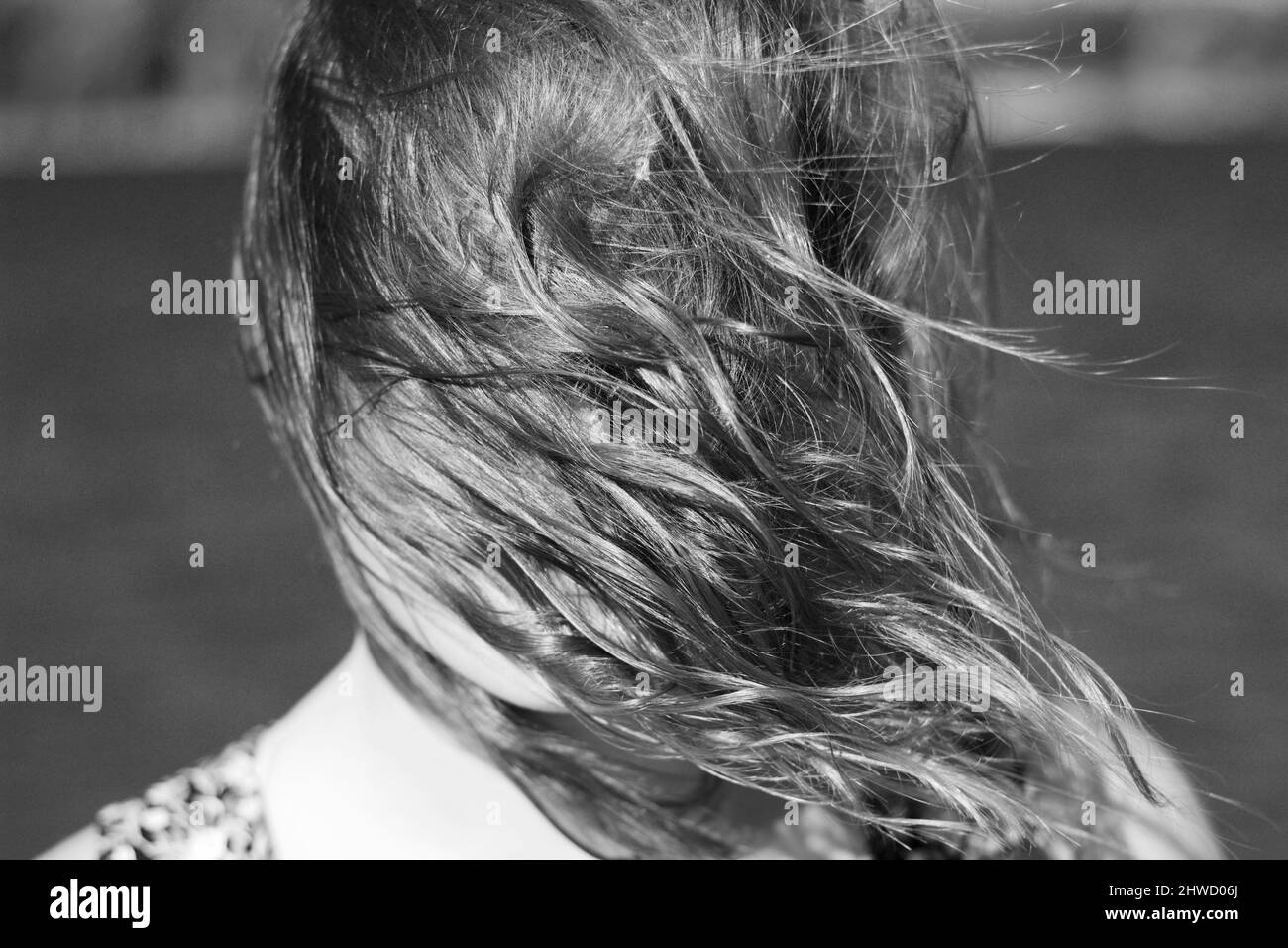 Ritratto di una donna su una riva del fiume in una giornata ventosa con i capelli che ricoprono il suo volto Foto Stock