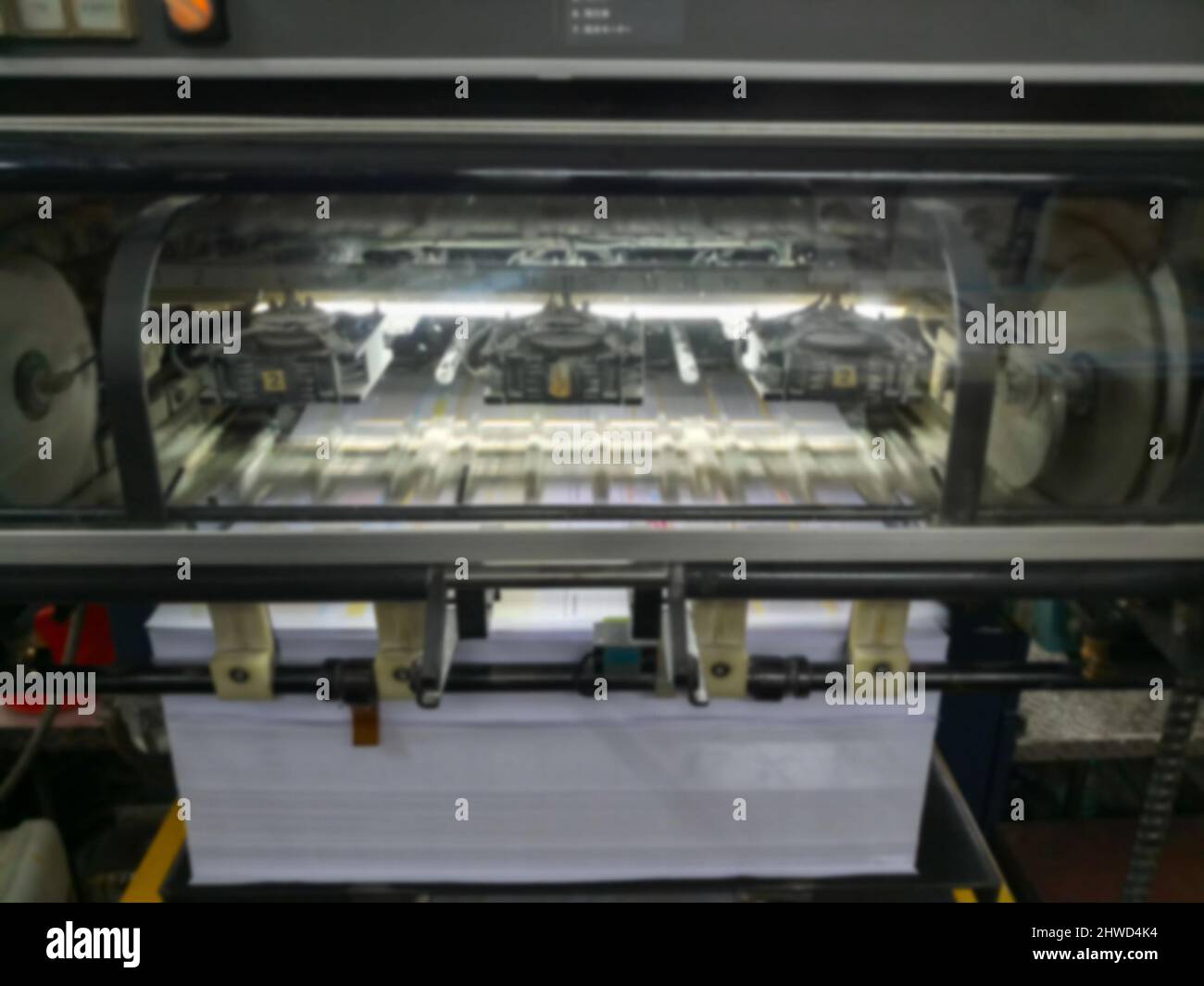 Immagine sfocata di una moderna macchina da stampa a quattro colori funzionante ad alta velocità. Girato a Kolkata, Bengala Occidentale, India. Foto Stock