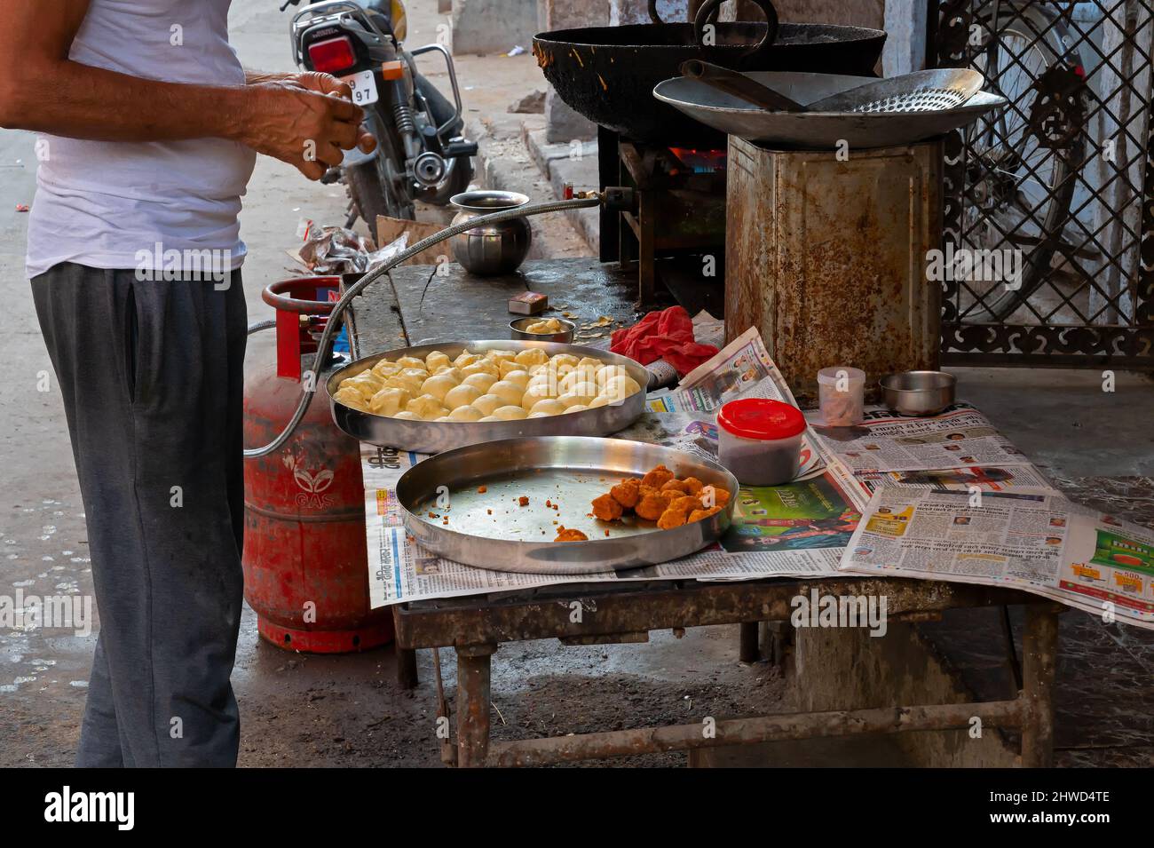 Jodhpur, Rajasthan, India - 21st ottobre 2019 : l'uomo che prepara la prima colazione al mattino per la vendita, usando la stufa a gas e i vadas, il centro di fast food accanto a r Foto Stock