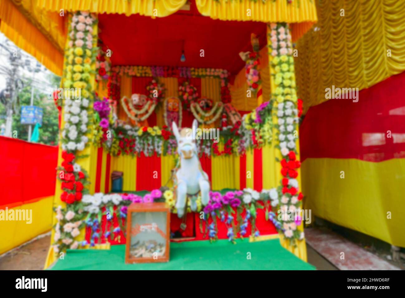 Immagine sfocata di Howrah, Bengala Occidentale, India. Soldi per adorare - scritto sulla scatola di raccolta in bengalese, Idol di Dio Jagannath, Balaram e Suvodra. Foto Stock