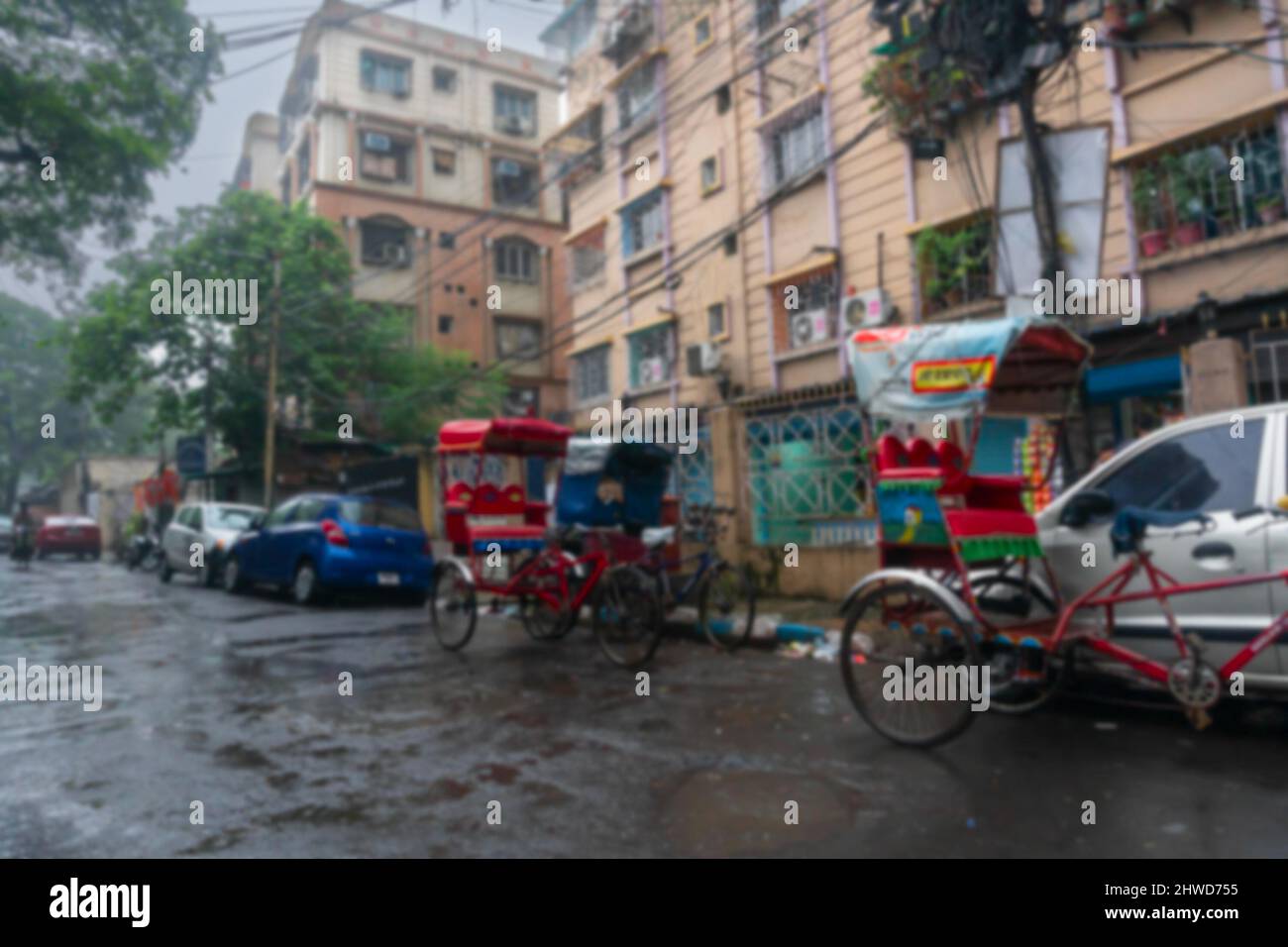 Immagine sfocata, immagine scattata attraverso gocce di pioggia che cadono su vetro bagnato, rickshaws tirato a mano sotto la pioggia - monsone immagine di riserva di Kolkata precedentemente Calcutta. Foto Stock