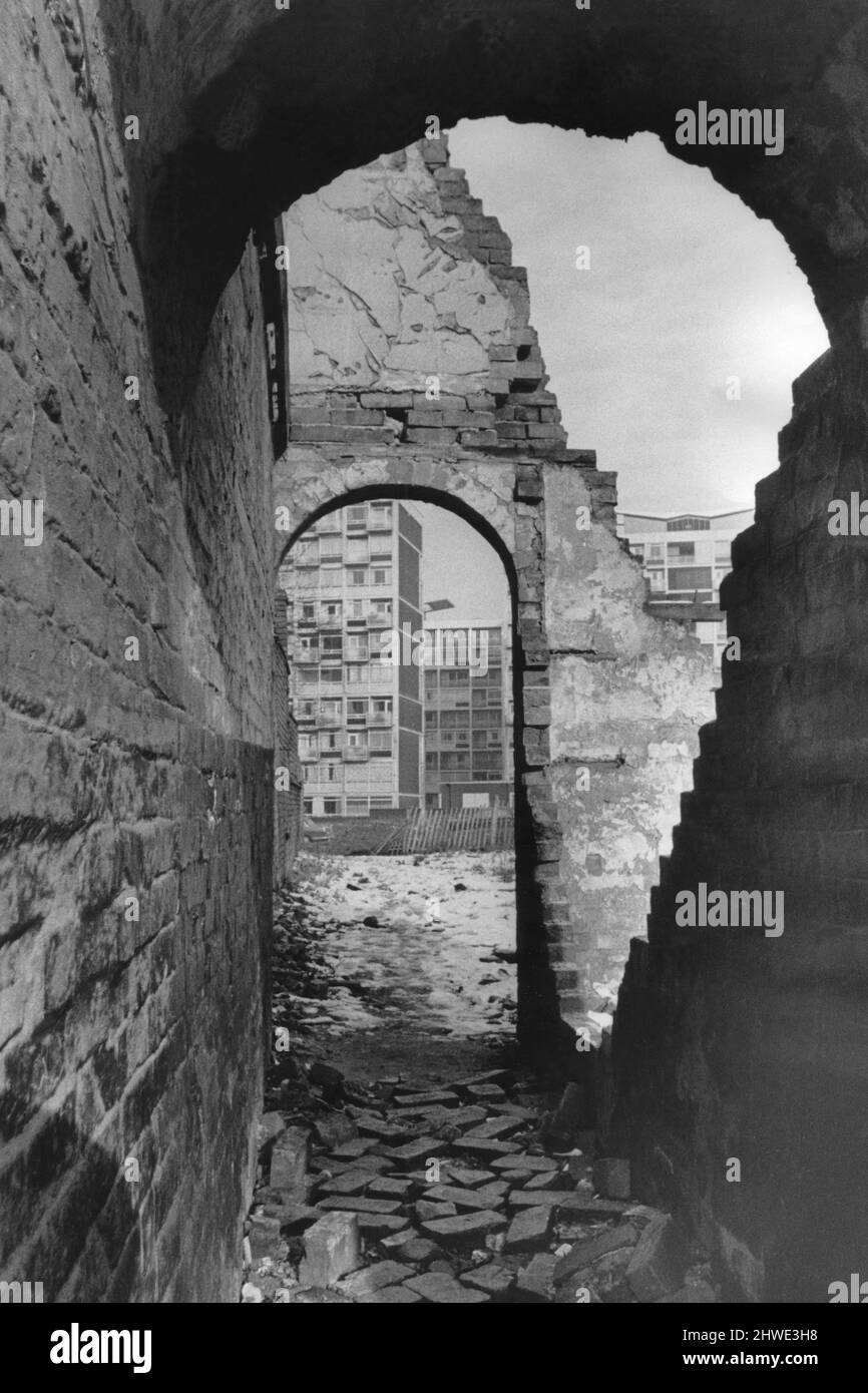 I bulldozer stanno liberando le vecchie strade di Hillfields per fare il posto agli appartamenti alti. La nostra fotografia mostra alcuni dei restanti edifici ancora da demolire con i nuovi appartamenti che si affacciano attraverso la vecchia arcata.11th Febbraio 1970 Foto Stock
