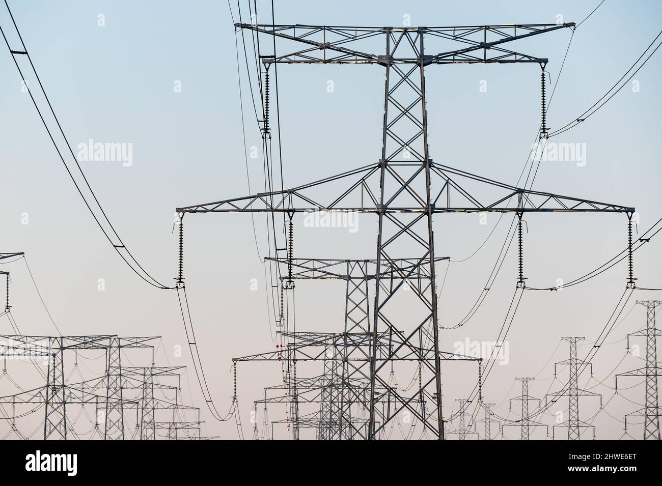 Cavi ad alta tensione in una torre di trasmissione per la distribuzione di energia elettrica. Foto Stock