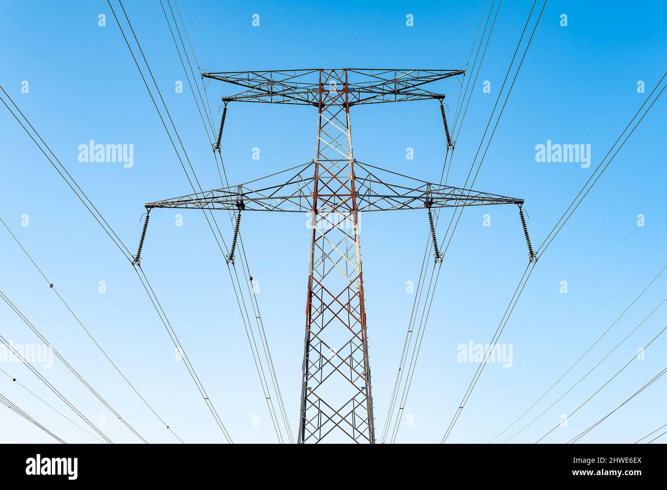 Cavi ad alta tensione in una torre di trasmissione per la distribuzione di energia elettrica. Foto Stock