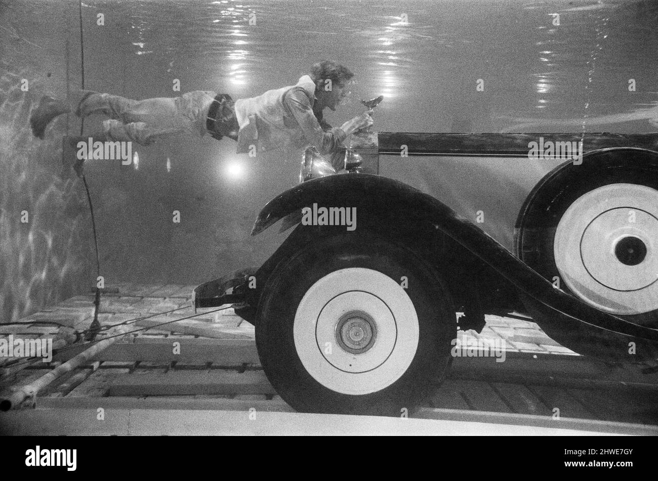 Michael Crawford, attore di 27 anni, che non usa stunt men in parti pericolose, filma sott'acqua con un Rolls Royce presso gli studi MGM di Elstree per la nuova produzione di volpe del Novecento, 'Hello - Arrivederci'. Le scene riprese sott'acqua sono state le sequenze finali della sequenza di superficie superiore originale eseguita a Cannes, dove Crawford ha guidato i rotoli in una piscina. Gli fu richiesto di trattenere il respiro per le telecamere per 3 minuti prima che la 'risrue' fosse fatta. 17th ottobre 1969. Foto Stock