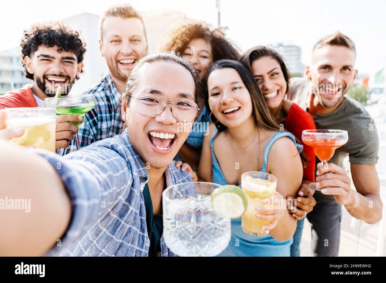 Giovani amici che prendono selfie con il telefono mentre bevono cocktail alla moda Foto Stock