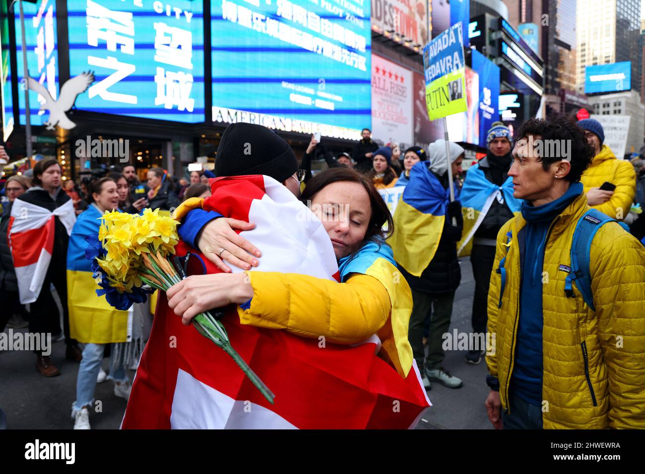 New York, Stati Uniti. 05 marzo 2022, New York City, New York, unisce gli stati: I manifestanti abbracciano durante un raduno di protesta contro l'invasione dell'Ucraina da parte della Russia a Times Square di New York City questo pomeriggio. Credit: Adam Stoltman/Alamy Live News Foto Stock