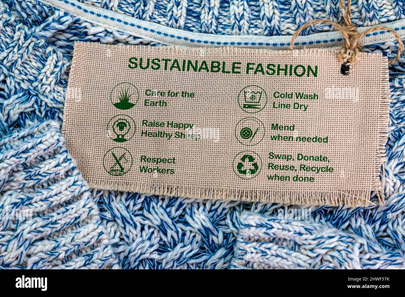 etichetta di moda sostenibile su jumper di lana con icone e testo di cura, consumismo etico Foto Stock