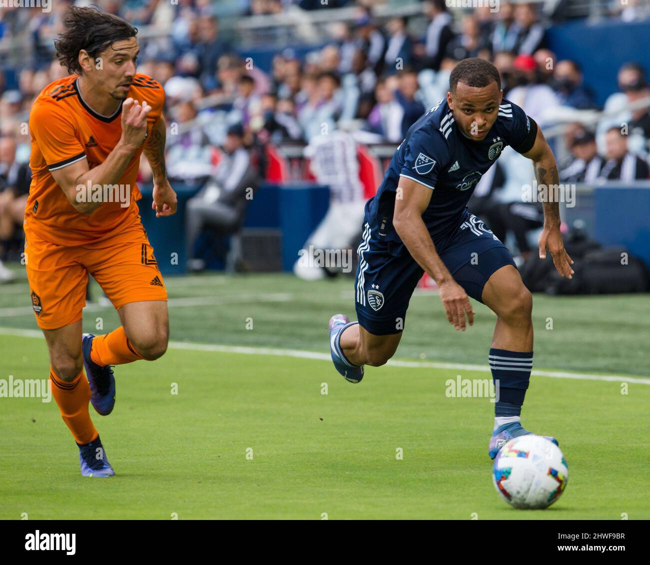 Kansas City, Kansas, Stati Uniti. 4th Mar 2022. Il difensore della KC sportiva Logan Ndenbe #18 (r) guida l'offesa contro il difensore della Houston Dynamo Zarek Valentin #4 (l) durante la prima metà del gioco. (Credit Image: © Serena S.Y. Filo pressa Hsu/ZUMA) Foto Stock
