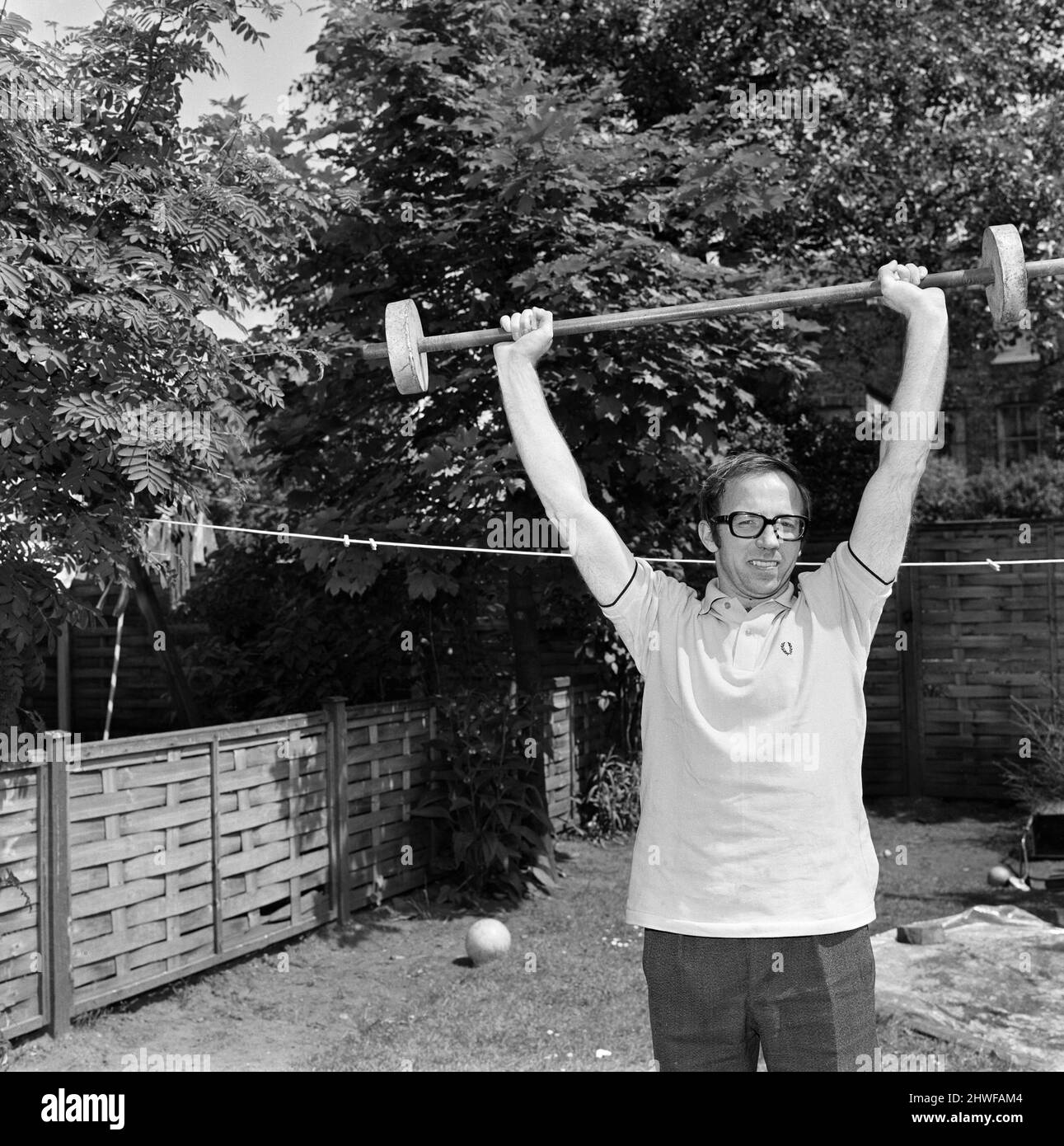 Il calciatore Nobby Stiles, che deve subire un'operazione alla gamba, ha mostrato di mantenere i muscoli più agili durante un esercizio di allenamento nel giardino posteriore della sua casa a Stretford, Manchester. 9th giugno 1969. Foto Stock