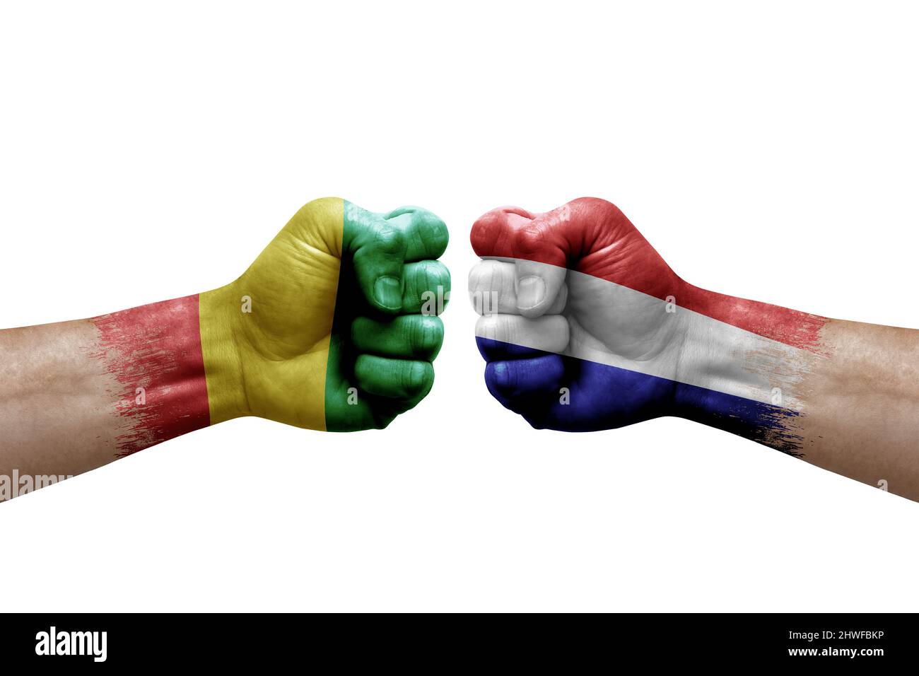 Due mani si pugno l'una all'altra su sfondo bianco. Bandiere di paese dipinte fists, concetto di crisi di conflitto tra Guinea e paesi bassi Foto Stock