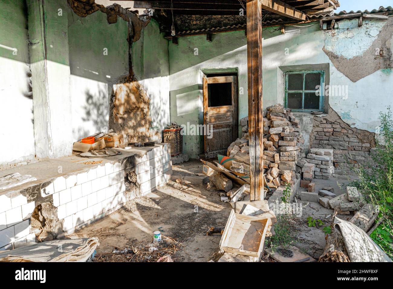 Costruzione di casa delapidated che mostra strati di сement e mattoni. Cumuli di mattoni nella casa distrutta Foto Stock