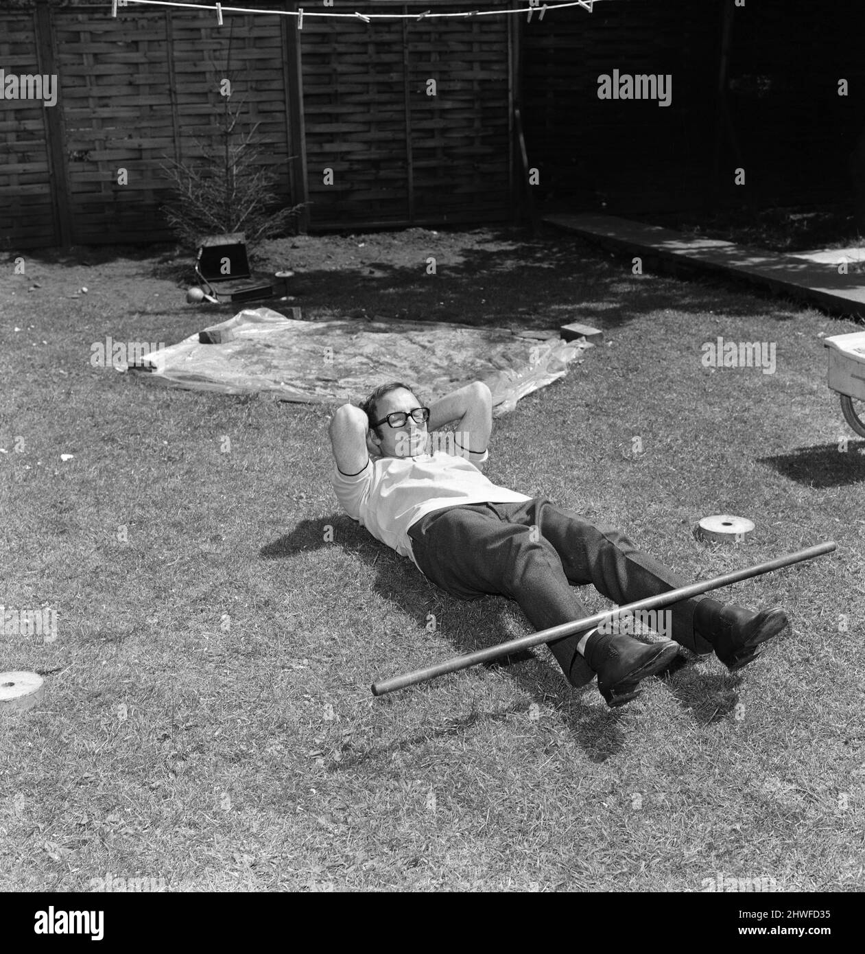 Il calciatore Nobby Stiles, che deve subire un'operazione alla gamba, ha mostrato di mantenere i muscoli più agili durante un esercizio di allenamento nel giardino posteriore della sua casa a Stretford, Manchester. 9th giugno 1969. Foto Stock