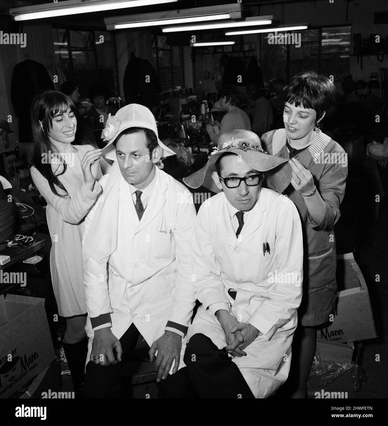 I cofani di Pasqua che sono fatti alla fabbrica di cappello di Edward Mann Ltd. A Stoke Newington. Roped dentro dalle ragazze come modelli mentre i cofani di Pasqua sono finiti fuori, sono Martin Levy, il capo dei lavori e Basil Mann (con i vetri) un direttore dell'azienda. Le ragazze sono Alice carter, con capelli lunghi, e Christine Rose, che sono entrambi macchinisti. 22nd gennaio 1969. Foto Stock