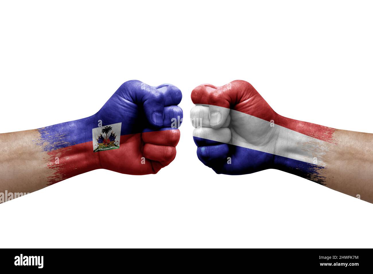 Due mani si pugno l'una all'altra su sfondo bianco. Bandiere di paese dipinte pugni, conflitto di crisi concetto tra haiti e paesi bassi Foto Stock