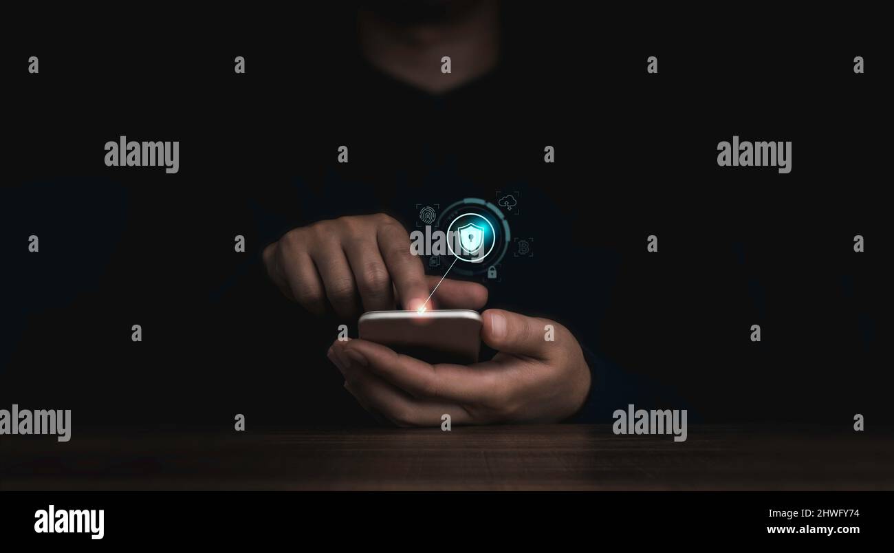 Il pulsante di blocco dello schermo e le icone delle informazioni personali vengono visualizzate mentre il dito dell'uomo tocca lo smartphone su sfondo scuro. Sicurezza informatica, dati Foto Stock