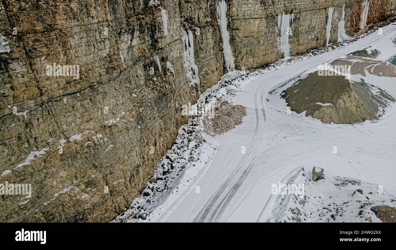 Formazioni di ghiaccio e neve sulle pareti di una cava. La neve si scioglie sulla terra soprastante e si riversa lungo le mura e si congela creando maestose formazioni. Foto Stock