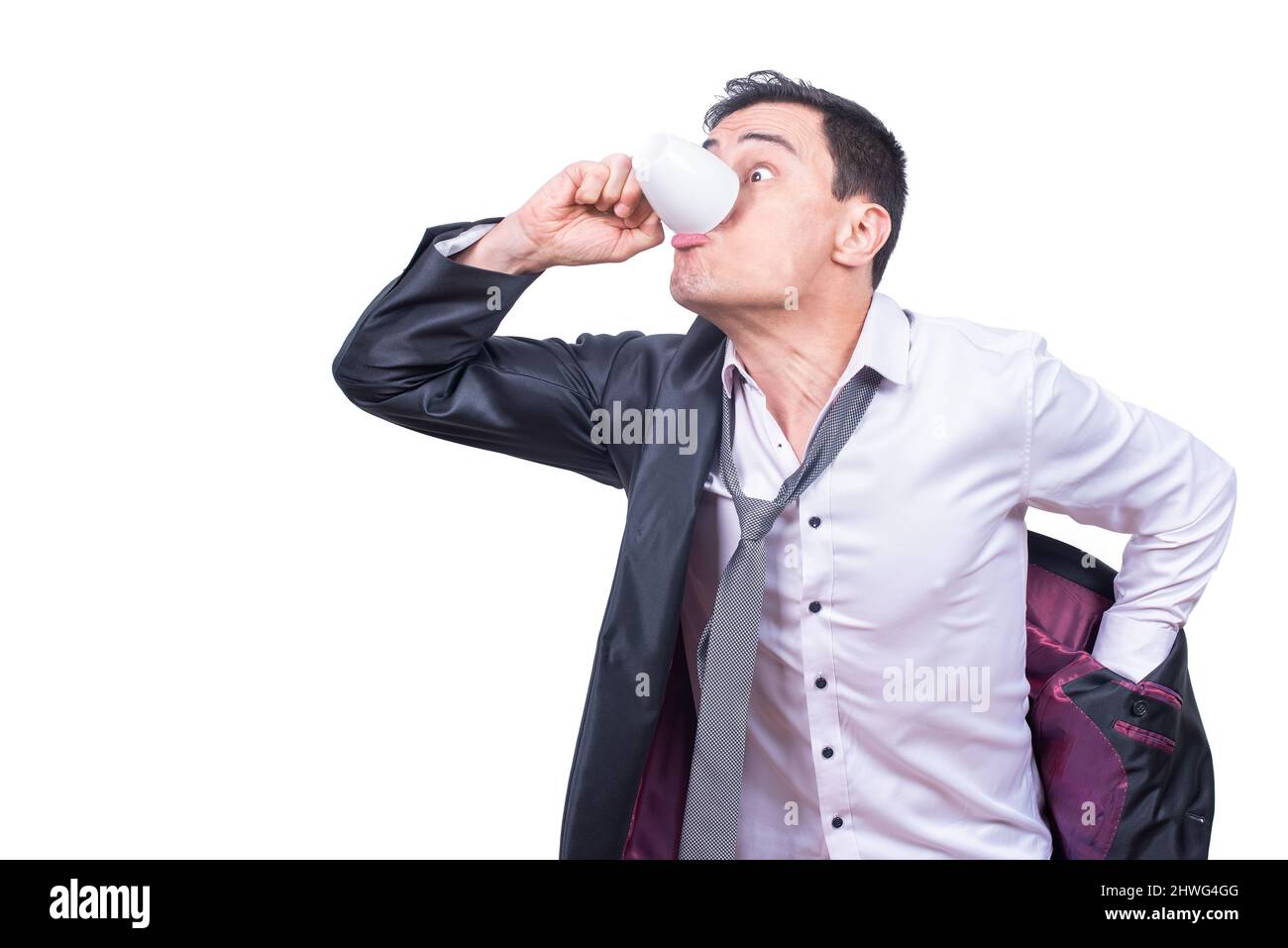 Hurying uomo d'affari che beve il caffè mentre mette sulla giacca Foto Stock