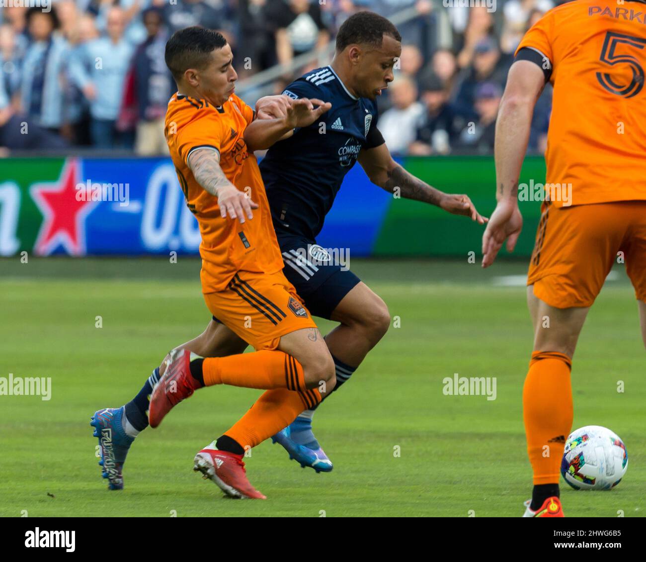Kansas City, Kansas, Stati Uniti. 4th Mar 2022. Il difensore della KC sportiva Logan Ndenbe #18 (r) vies per l'offesa di campo centrale contro il centrocampista di Houston Dynamo Matias vera #22 (l) durante la prima metà del gioco. (Credit Image: © Serena S.Y. Filo pressa Hsu/ZUMA) Foto Stock