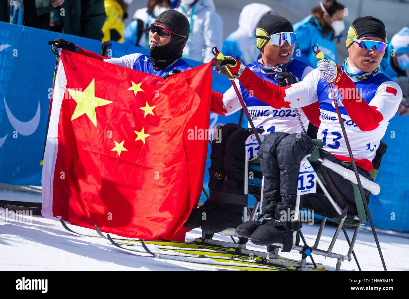 Zhangjiakou, Cina. 06th Mar 2022. Paralimpiadi, Para Ski Nordic, cross-country, 18km, seduta, Uomini, Peng Zheng (M) della Cina, Zhongwu Mao (r) della Cina e Tina Du (l) della Cina al traguardo dopo la gara del 18km. Zheng vince la medaglia d'oro. Credit: Jens Büttner/dpa-Zentralbild/dpa/Alamy Live News Foto Stock