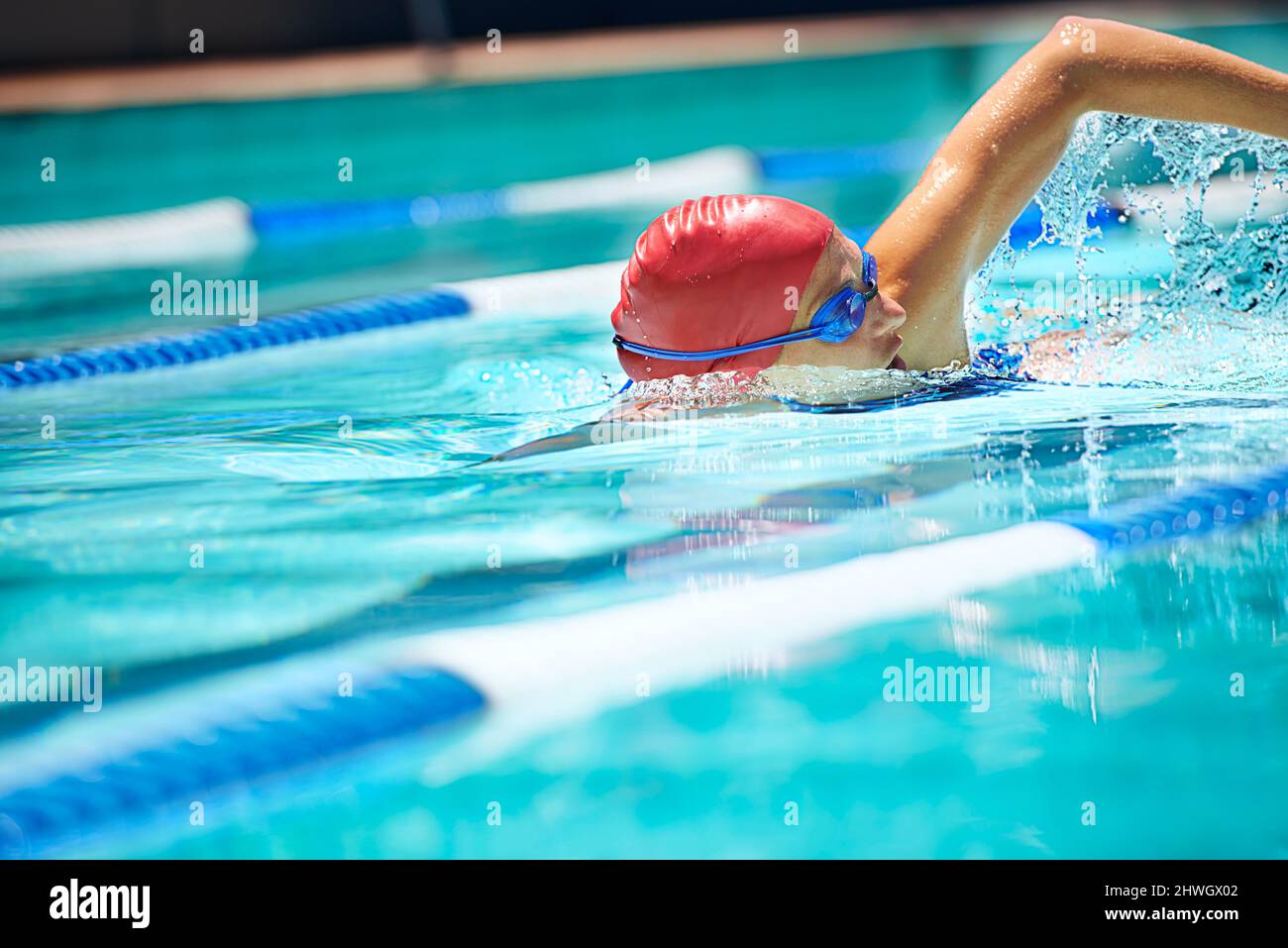 Lavorando sul suo colpo. Scatto di una nuotatrice professionista femminile freestyle nuoto nella sua corsia. Foto Stock