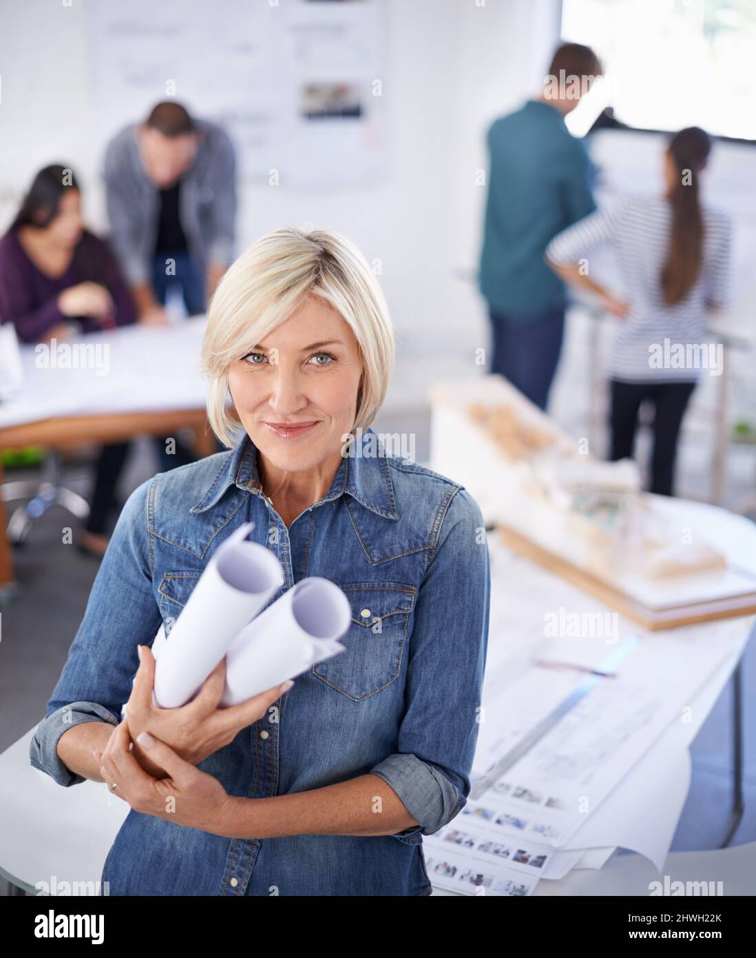 Ha grandi progetti per il futuro. Ritratto di una donna matura architetto in piedi in un ufficio con progetti. Foto Stock