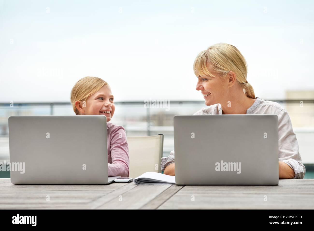 Proprio come sua mamma. Scatto di una ragazza e di sua madre usando i computer portatili fianco a fianco. Foto Stock