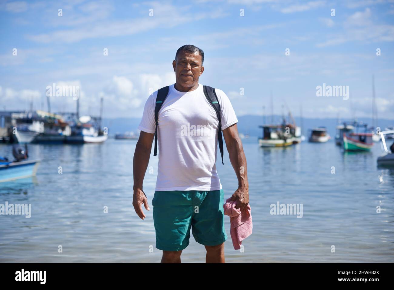 La pesca è la mia vita. Ritratto di un pescatore in piedi in acque poco profonde nel porto. Foto Stock