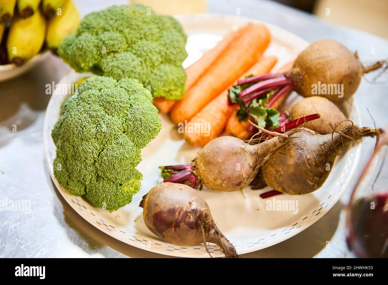 Piatto con broccoli, barbabietole e altri ingredienti in cucina Foto Stock