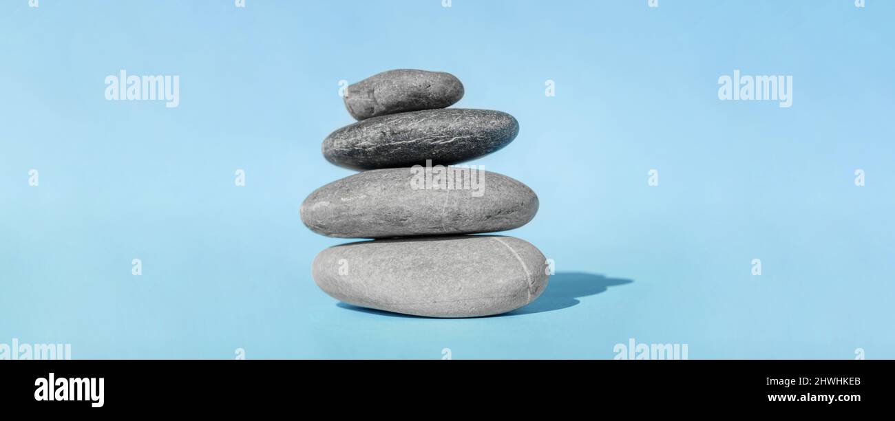 Il cairn equilibrante - simbolo di armonia, tranquillità e relax, concetto di meditazione. Stack di pietre calde spa. Foto Stock