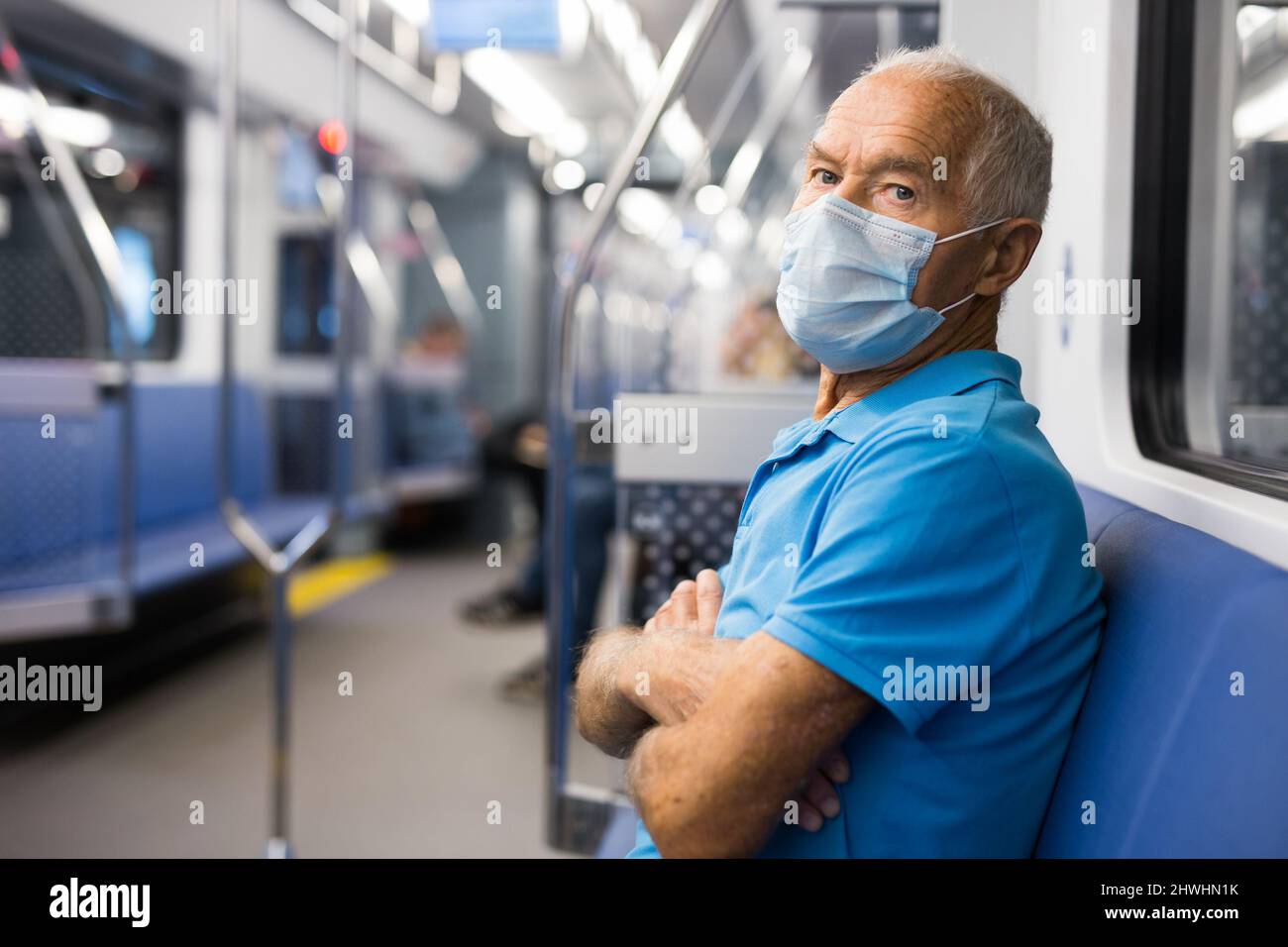 Ritratto di uomo adulto in maschera usa e getta viaggiando in treno della metropolitana durante tutti i giorni. Concetto di precauzioni durante l'uso dei trasporti pubblici in COVID 19 Foto Stock