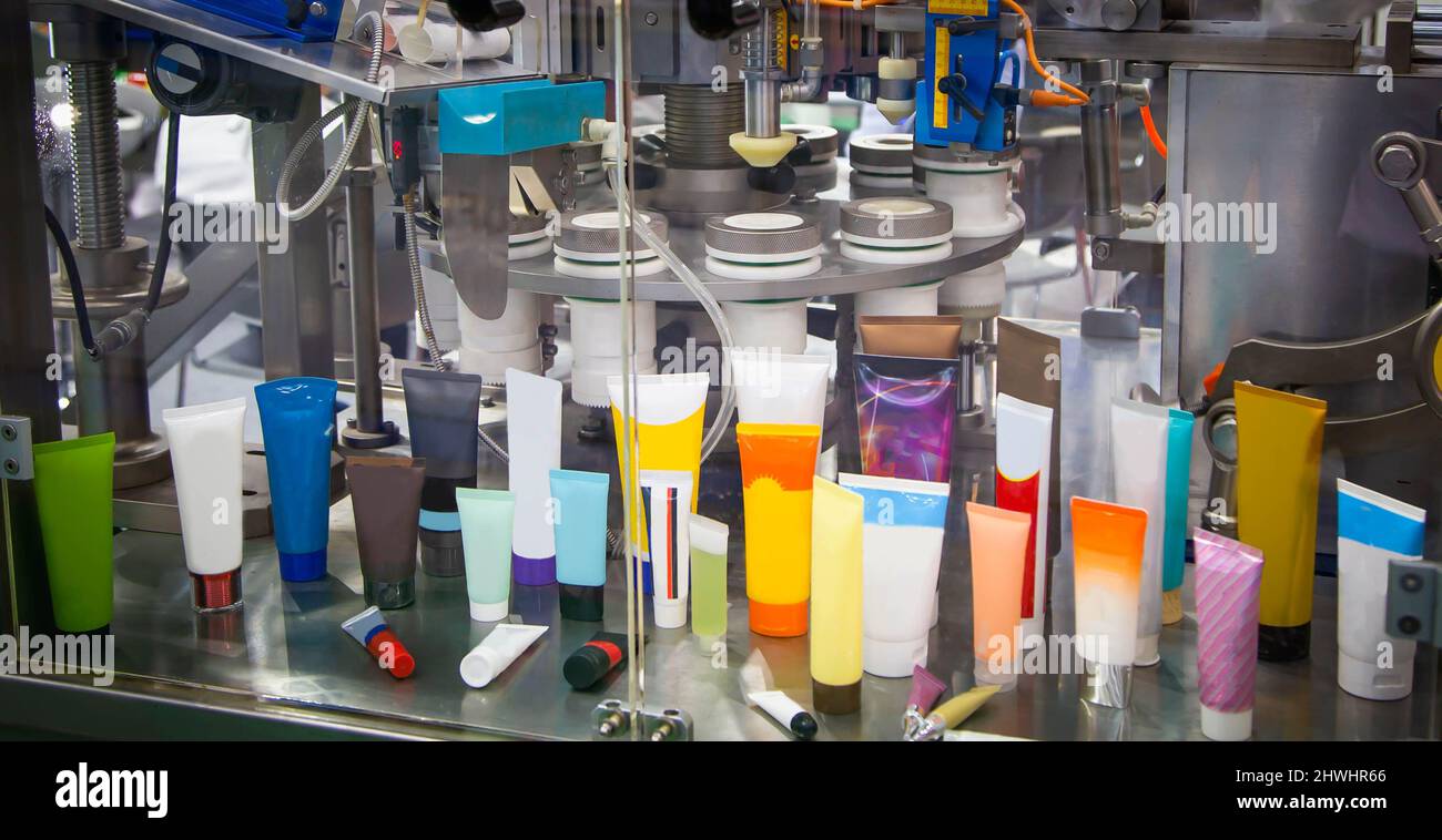Processo di riempimento e sigillatura automatico di tubi cosmetici. Industria farmaceutica. Foto Stock