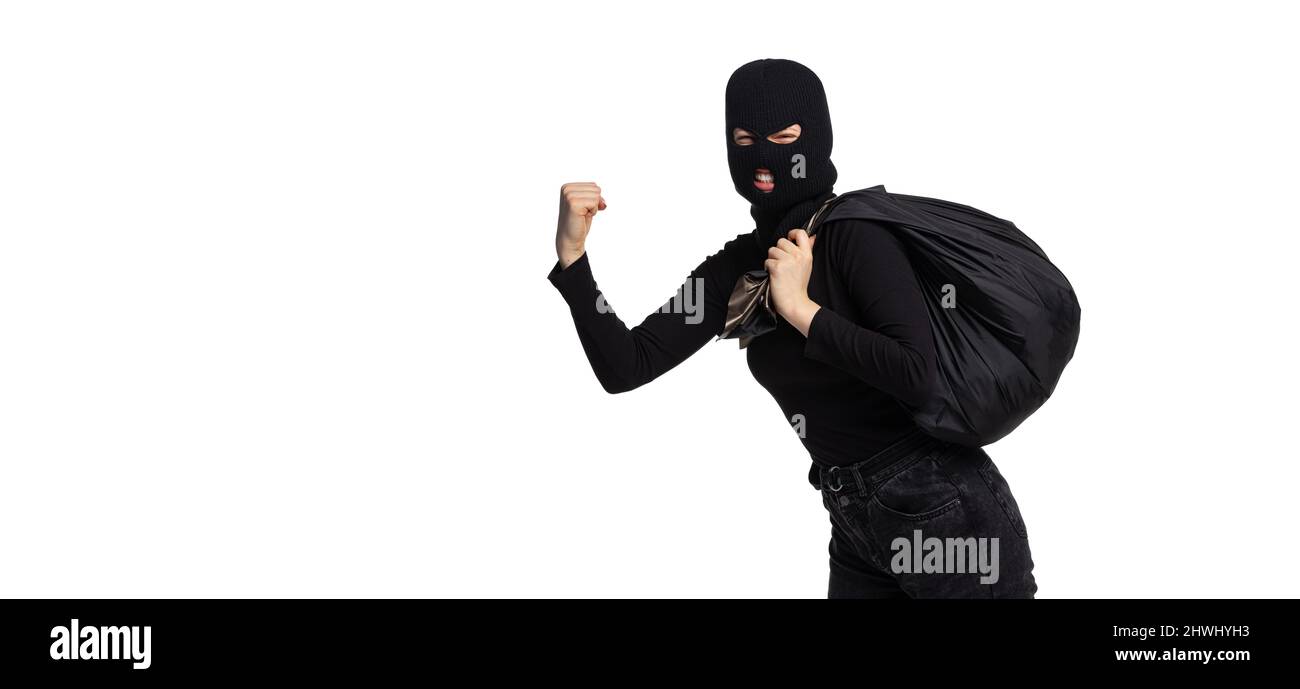 Ritratto di giovane anonimo indossando abiti neri e balaclava isolato su sfondo bianco. Concetto di arte, moda, anti-terrorizm Foto Stock