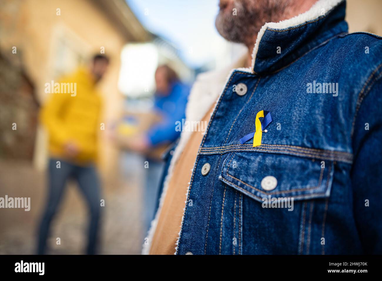 I manifestanti con i nastri blu e giallo ucraini protestano per strada contro la guerra in Ucraina Foto Stock