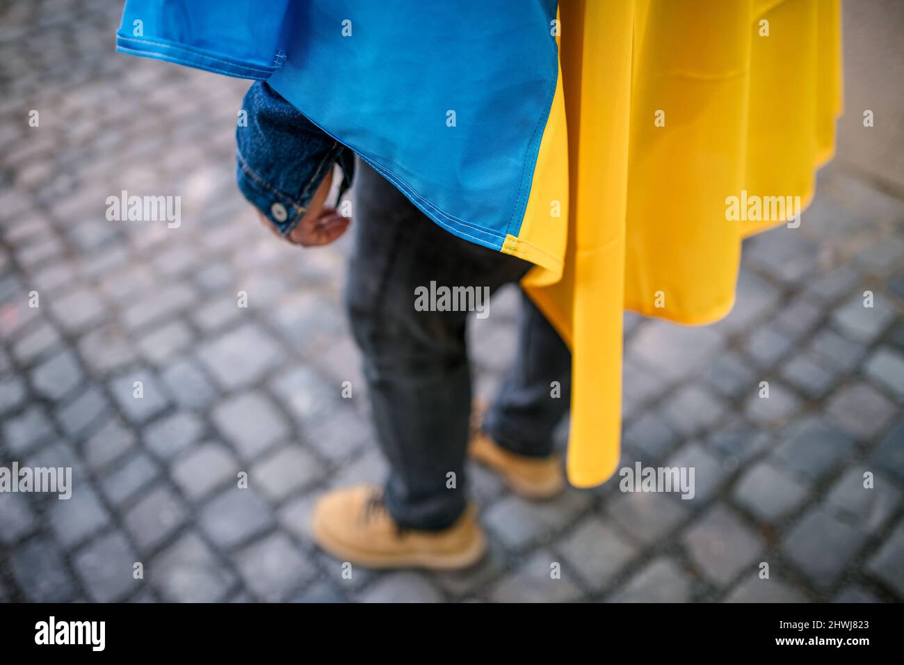 Lowsection del protestor coperto con bandiera Ucraina blu e gialla che protestava contro la guerra in Ucraina per strada Foto Stock