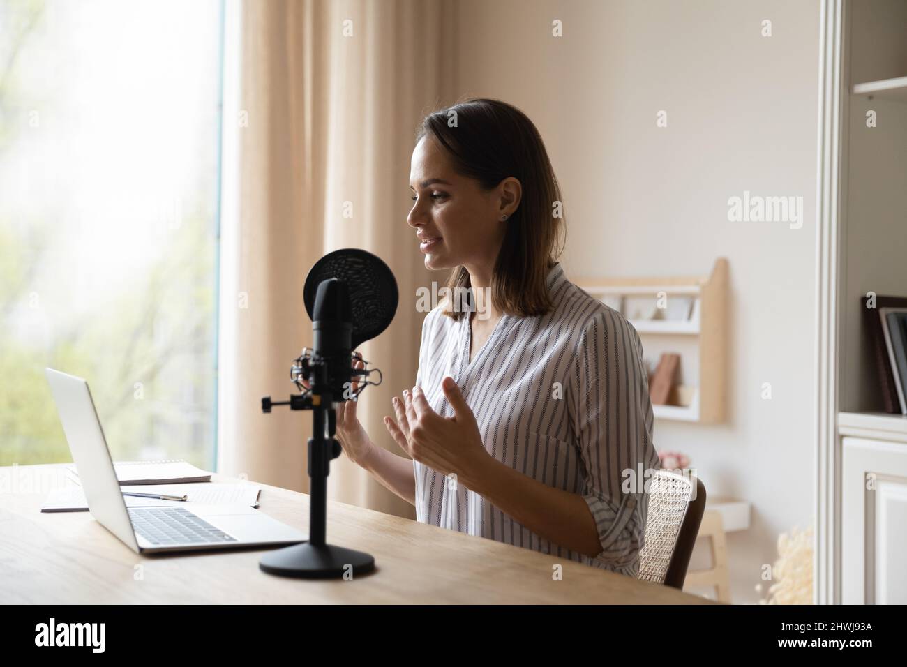 La donna parla nel microfono, partecipa allo streaming online Foto Stock