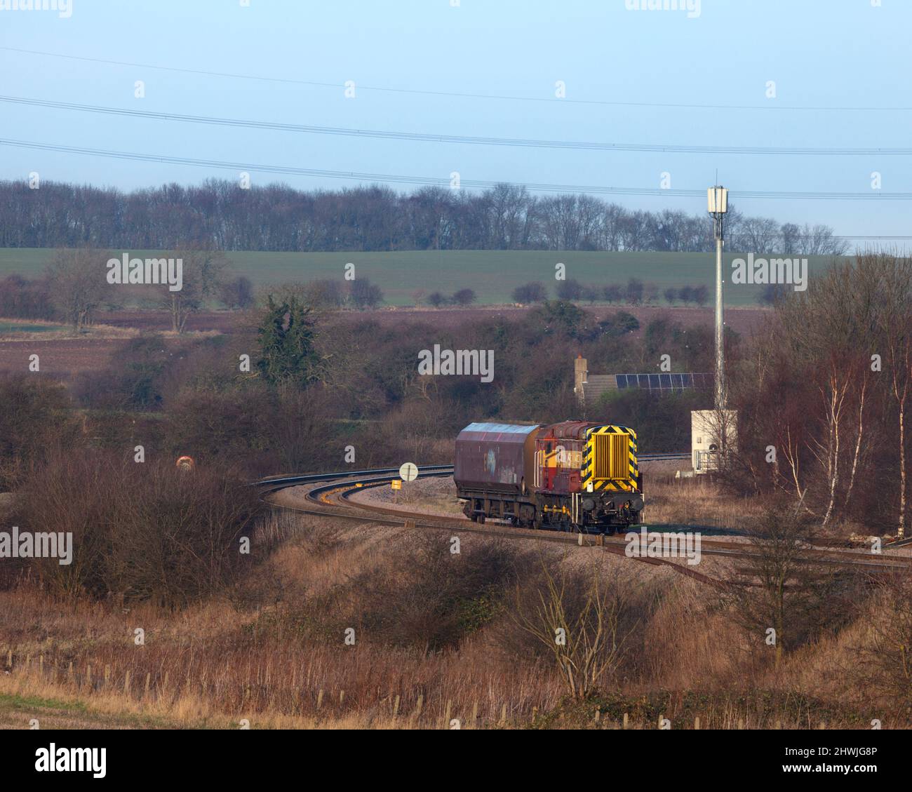 DB Schenker classe 08 locomotiva da shunting 08703 che trasporta un unico carro da carbone HTA che passa sulla linea principale passando per Burton Salmon Foto Stock