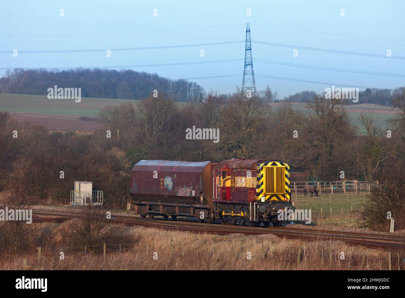 DB Schenker classe 08 locomotiva da shunting 08703 che trasporta un unico carro da carbone HTA che passa sulla linea principale passando per Burton Salmon Foto Stock
