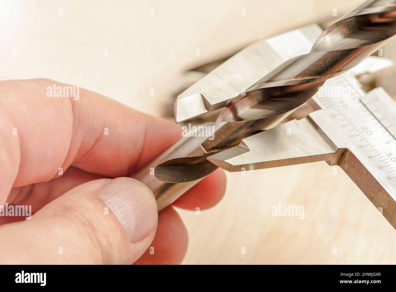 la pinza misura la punta su metallo, misura lo spessore dell'utensile di foratura in una macchina da perforazione industriale. Industria metallurgica Foto Stock