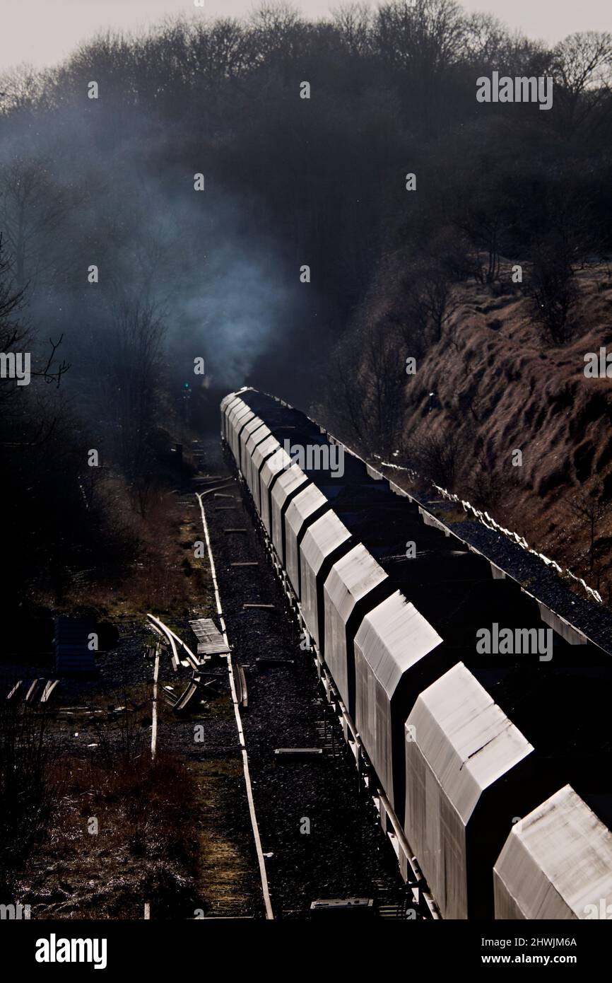 Un treno a carbone Freightliner sulla sezione a binario singolo a Kirton Lime Sidings, Lincolnshire, con fumi diesel e inquinamento dallo scarico Foto Stock